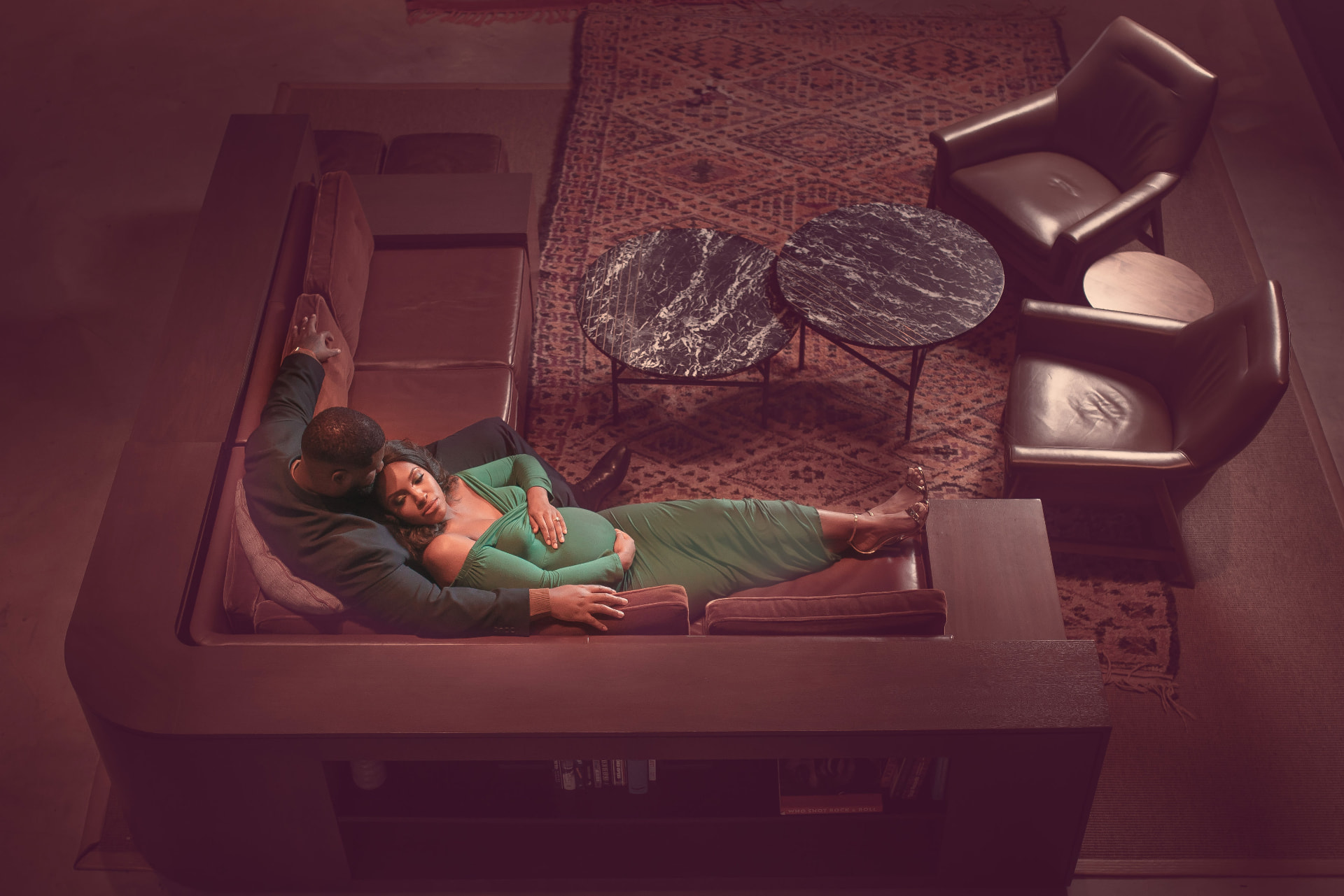 Expecting couple resting together on a lounge sofa