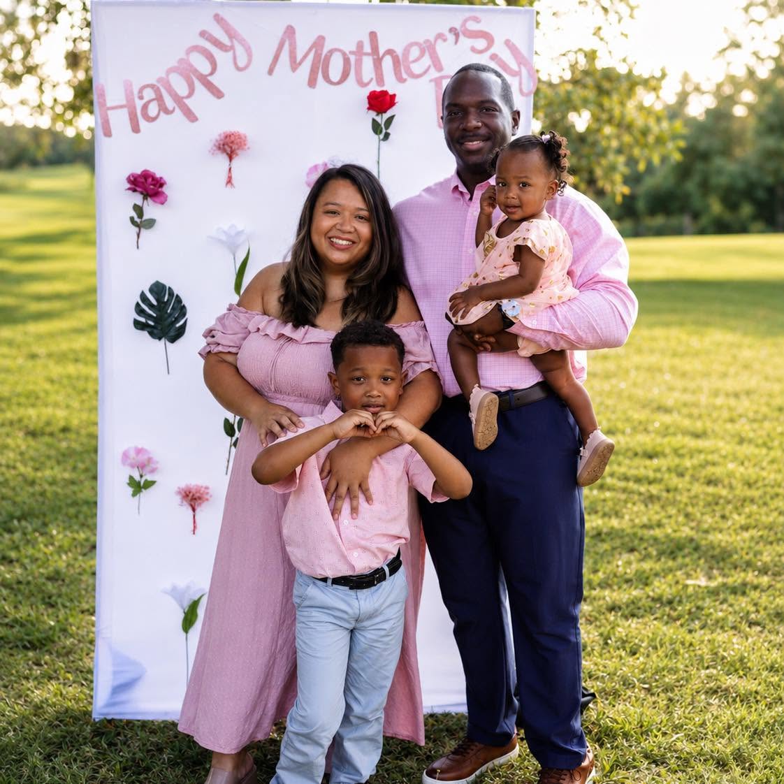 A family of four photographed outdoors at golden hour