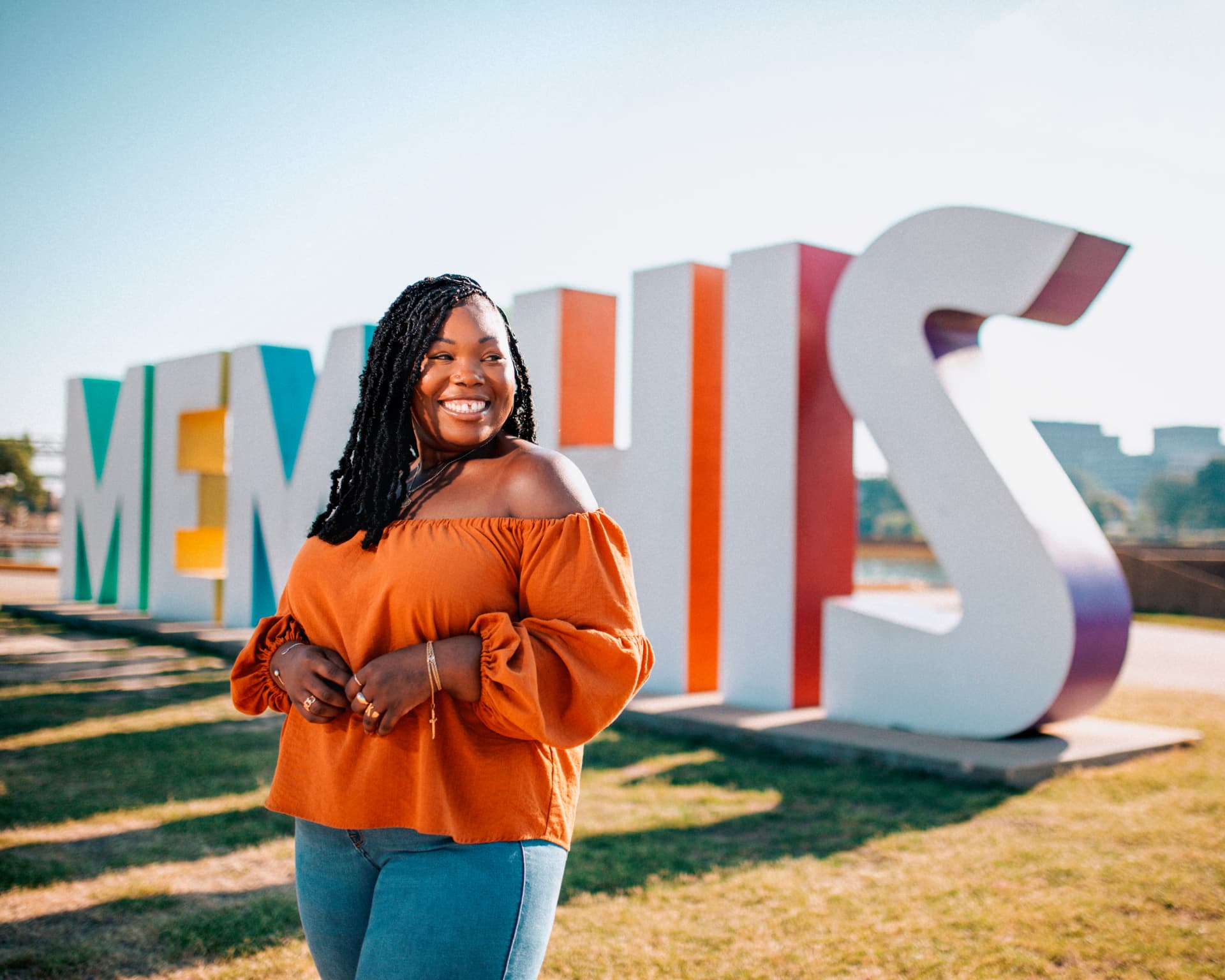 Smiling woman in front of the colorful Memphis sign