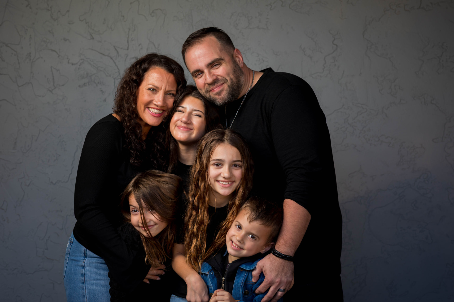 Extended family portrait against a textured wall
