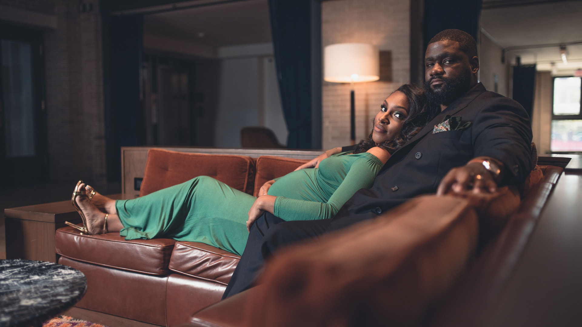 Maternity couple portrait in a warm loft lounge
